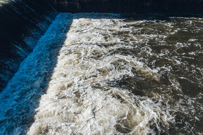High angle view of water flowing in dam