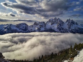 Sea of clouds in the valley in the snow-covered dolomites, italy
