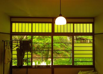 Close-up of illuminated electric lamp hanging on window