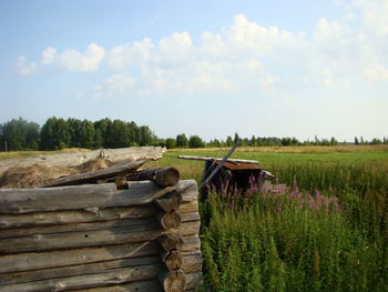 Wooden fence on field against sky