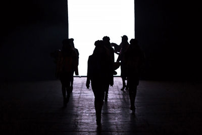 Rear view of silhouette people walking in corridor