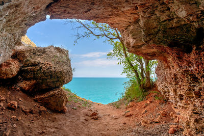 Rock formations by sea against sky