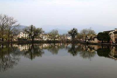 Reflection of trees in water against sky