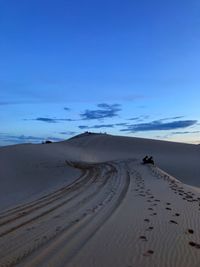 Scenic view of desert against blue sky