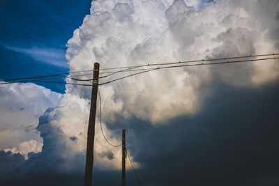 Low angle view of power lines against blue sky