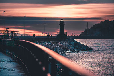 Bridge over sea against sky during sunset