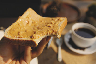 Close-up of hand holding coffee cup