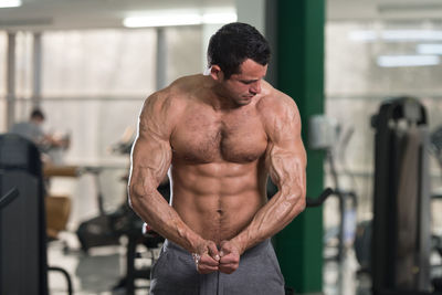 Shirtless man exercising in gym