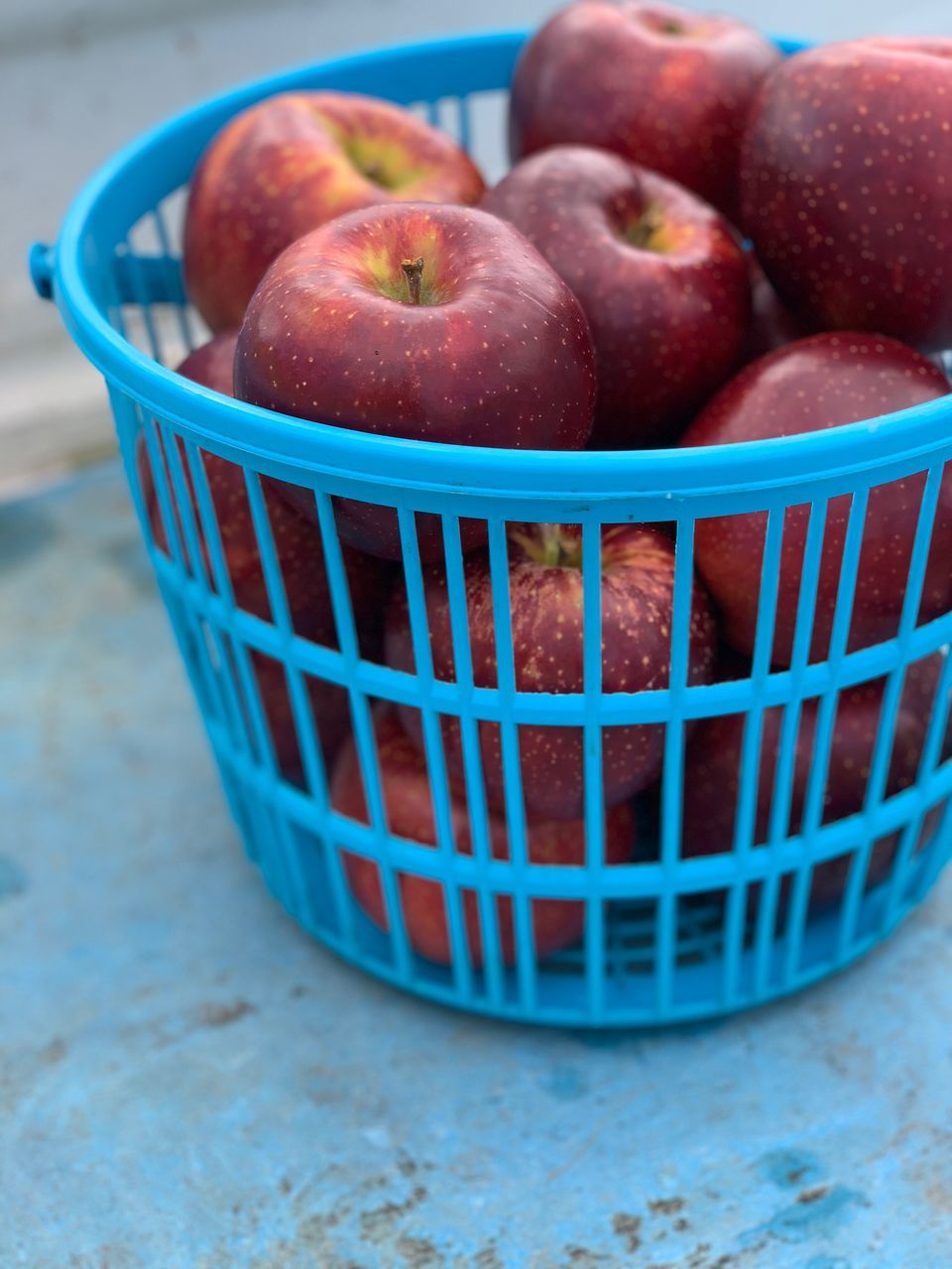 CLOSE-UP OF APPLES IN BASKET ON TABLE