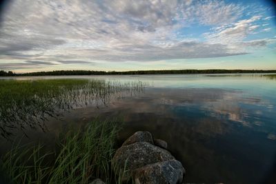 Scenic view of lake against cloudy sky