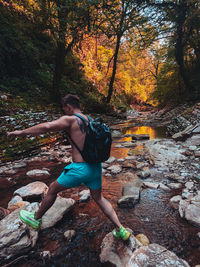 Rear view of man by trees in forest