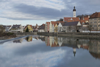 Reflection of buildings in river against sky