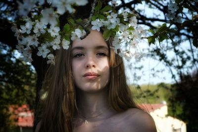 Portrait of girl under white flowering tree