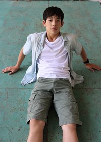 Portrait of teenage boy standing against wall