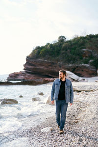 Full length portrait of man standing on rock