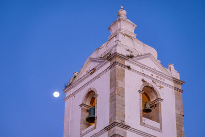 Low angle view of illuminated building against clear blue sky