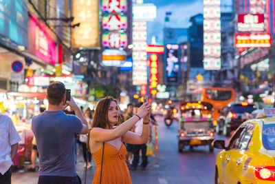 Women standing on city street at night