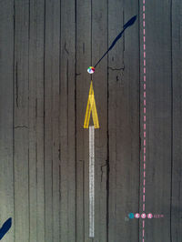 Aerial view of arrow symbol and umbrella on road