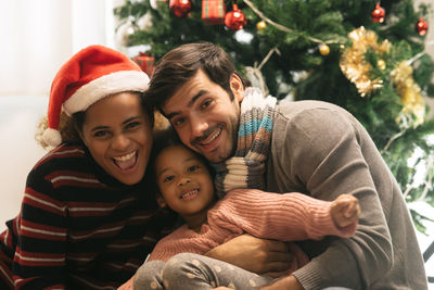 Rear view of a smiling young woman with christmas tree