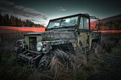 Abandoned truck on field against sky