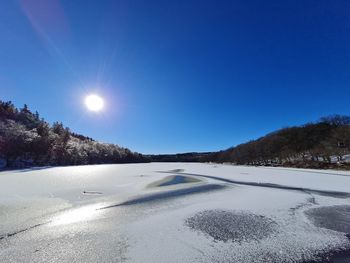 Scenic view of snow covered landscape against clear blue sky