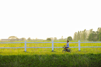 Full length of boy riding bicycle on field