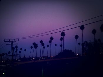 Electricity pylon against sky at dusk