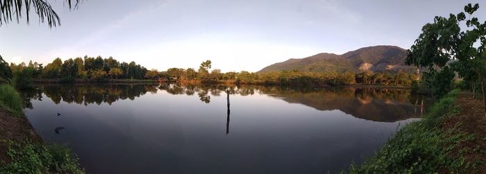 Scenic view of lake by trees against sky