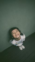 Portrait of smiling girl against wall