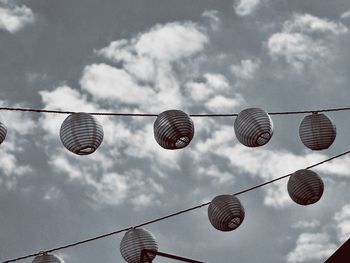 Low angle view of lanterns hanging against sky