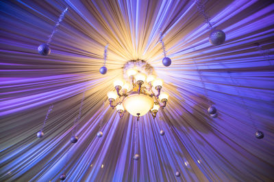 Low angle view of illuminated chandelier hanging