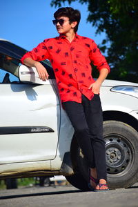 Full length of young woman standing on car