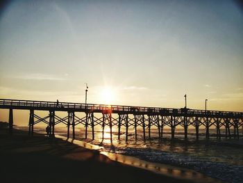 Pier on sea at sunset