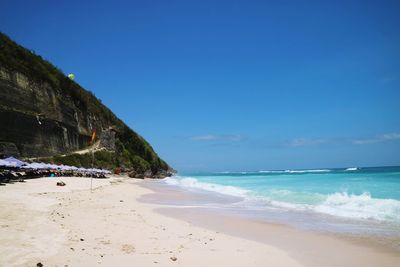 Scenic view of beach against blue sky