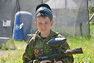 Portrait of boy wearing camouflage clothing on field
