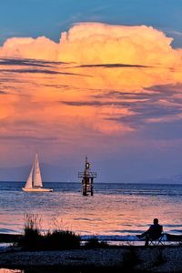 Sailboat sailing on sea against sky during sunset