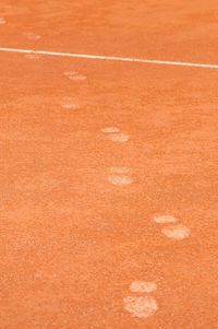 High angle view of footprints on tennis court