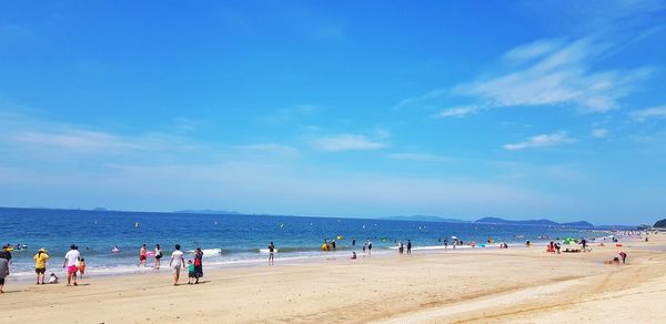 People at beach against sky