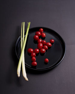 High angle view of tomatoes in container on table against black background