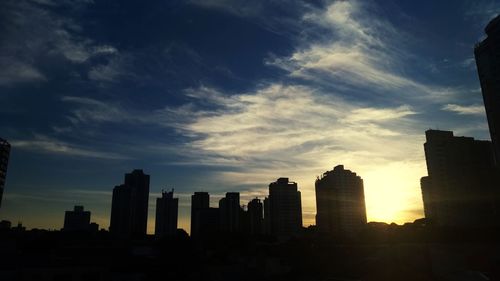 Silhouette buildings against sky during sunset