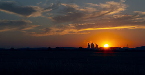 Scenic view of silhouette field against sky during sunset