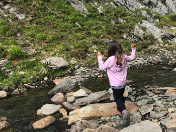 Rear view of woman walking on rocks