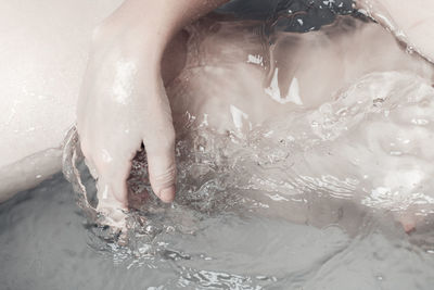 Midsection of naked woman in water