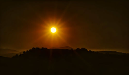 Scenic view of silhouette mountains against sky at sunset