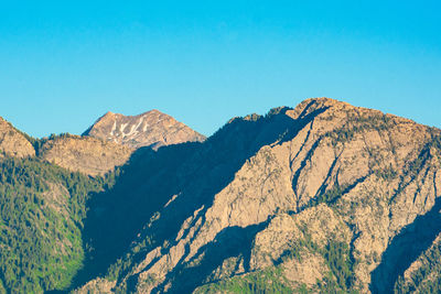 Scenic view of mountains against clear blue sky