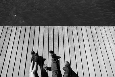 Low section of people standing on wooden post