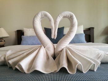 Blankets arranged in heart shape on bed