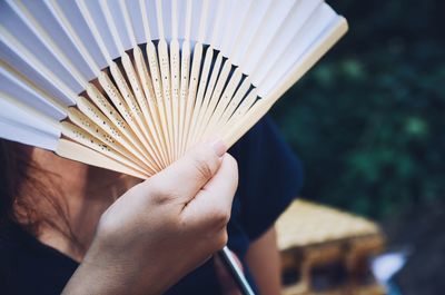 Close-up of hand holding fan