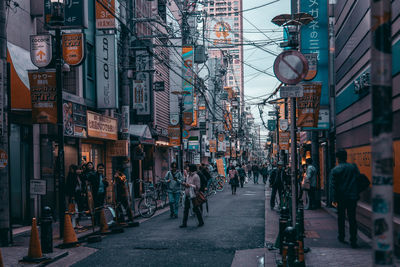 People walking on street amidst buildings in city
