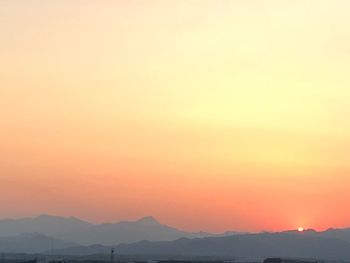 Scenic view of silhouette mountains against orange sky